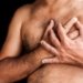 Shirtless man suffering a heart attack and grabbing his chest