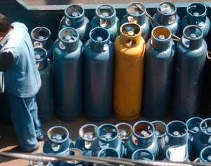 ( MÉXICO - DF,  JUL 2015 )   Un repartidor de tanques de gas, almuerza dentro de la unidad que transporta dichos cilindros