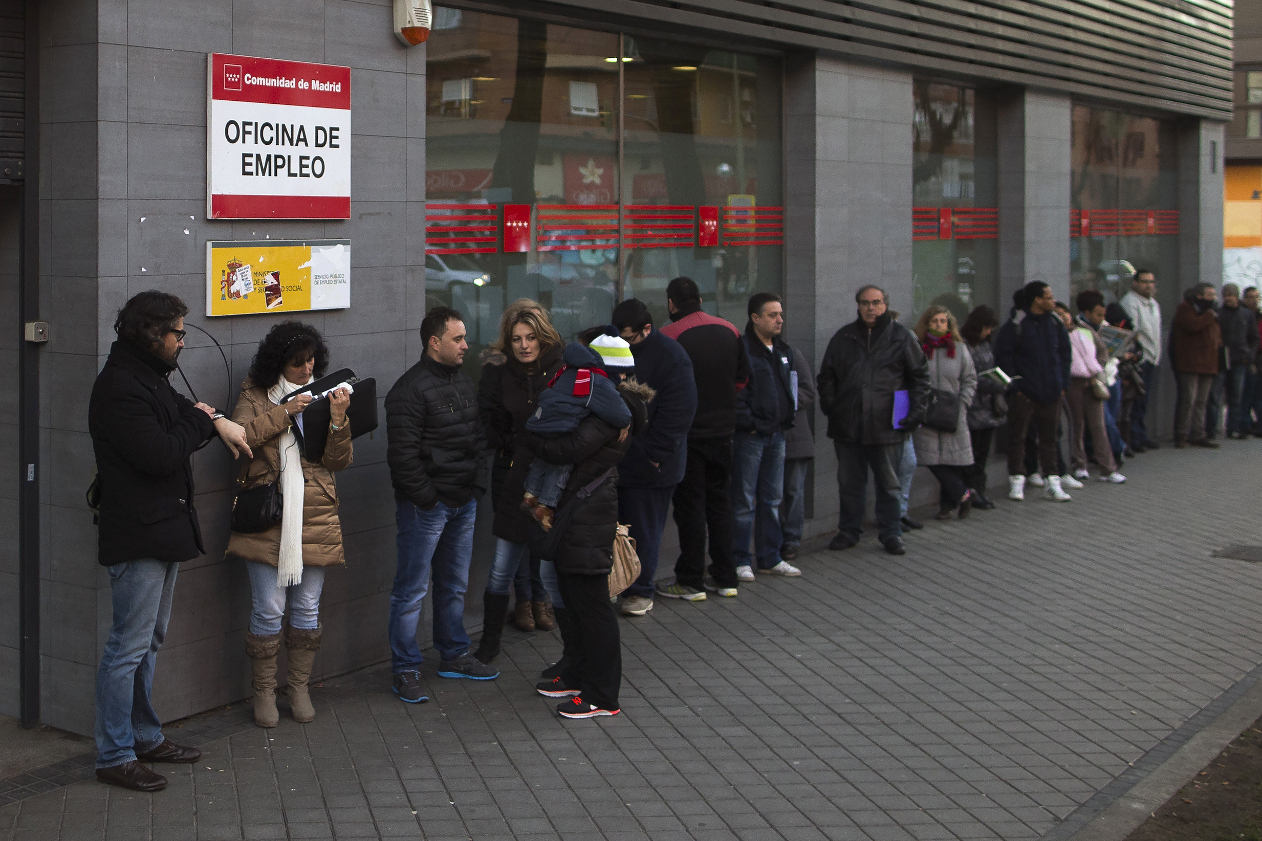 People wait in line to enter an unemployment registry office in Madrid, Spain, Thursday, Jan. 23, 2014.